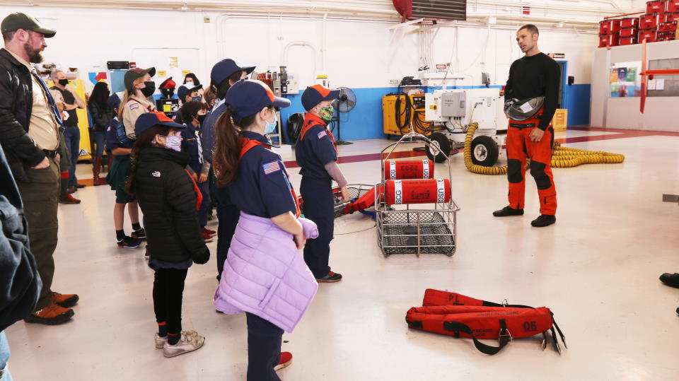 Coastguardsman explains Cubs some of the rescue equipment they use on their helicopter