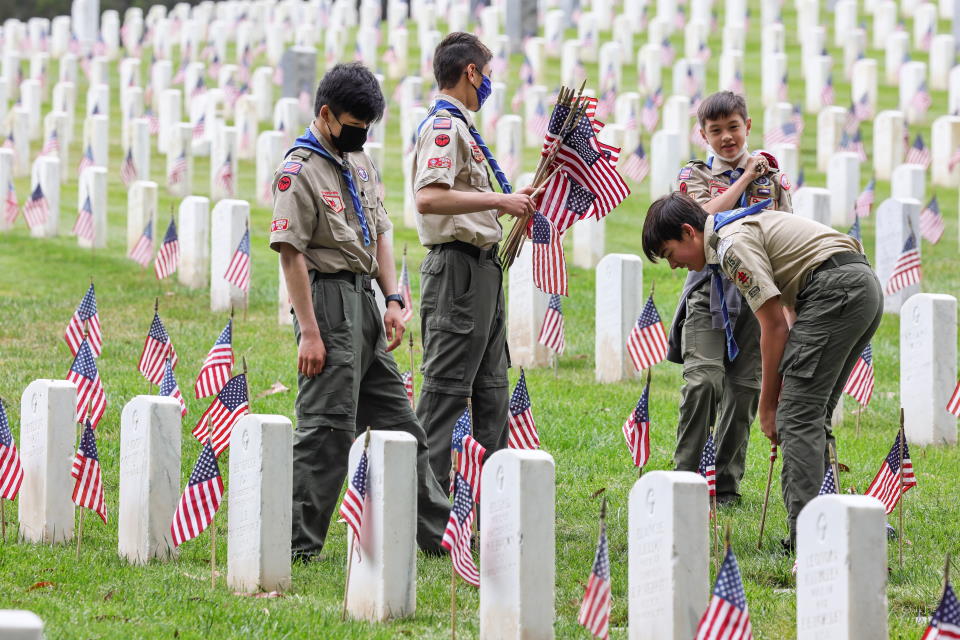 Scouts planting flags at grave markers