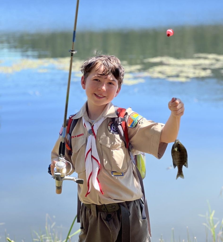 Scout at water's edge with his catch of the day
